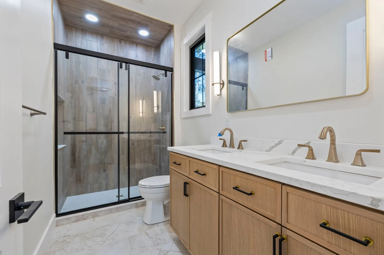 Primary bathroom with a tiled walk-in shower and double vanity