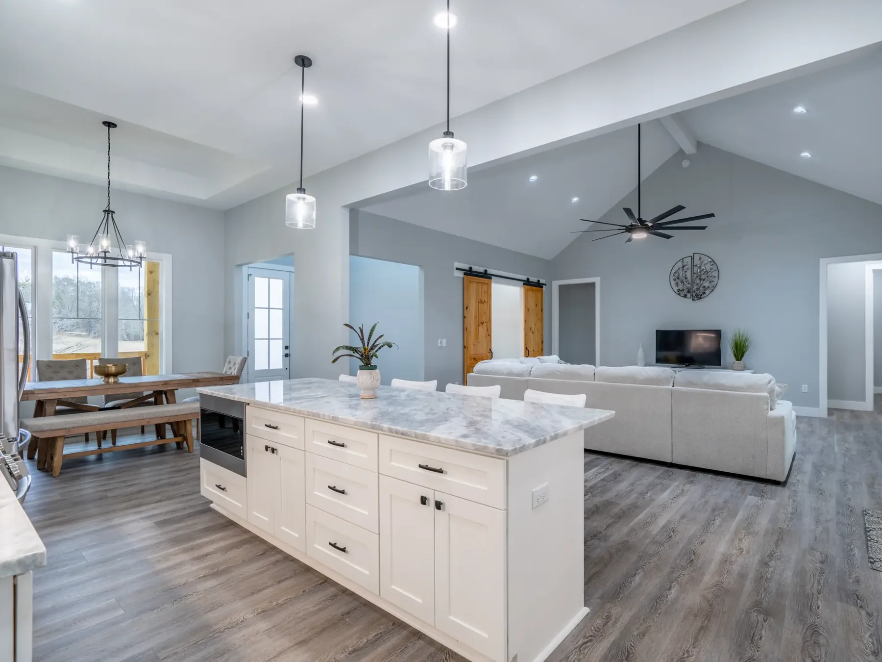 Open floor plan kitchen and living area with vaulted ceilings and hardwood floors