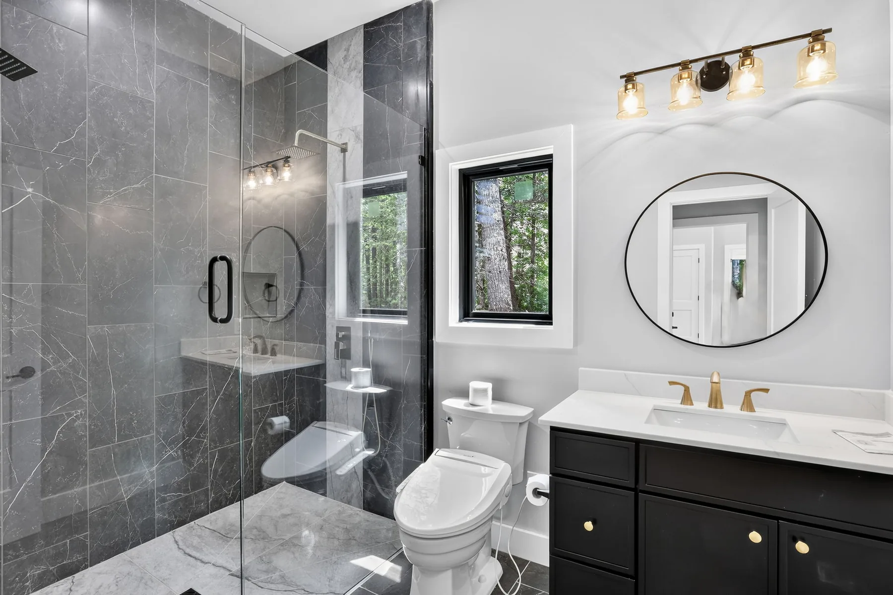 Primary bathroom with a tiled glass walk-in shower and brass fixtures