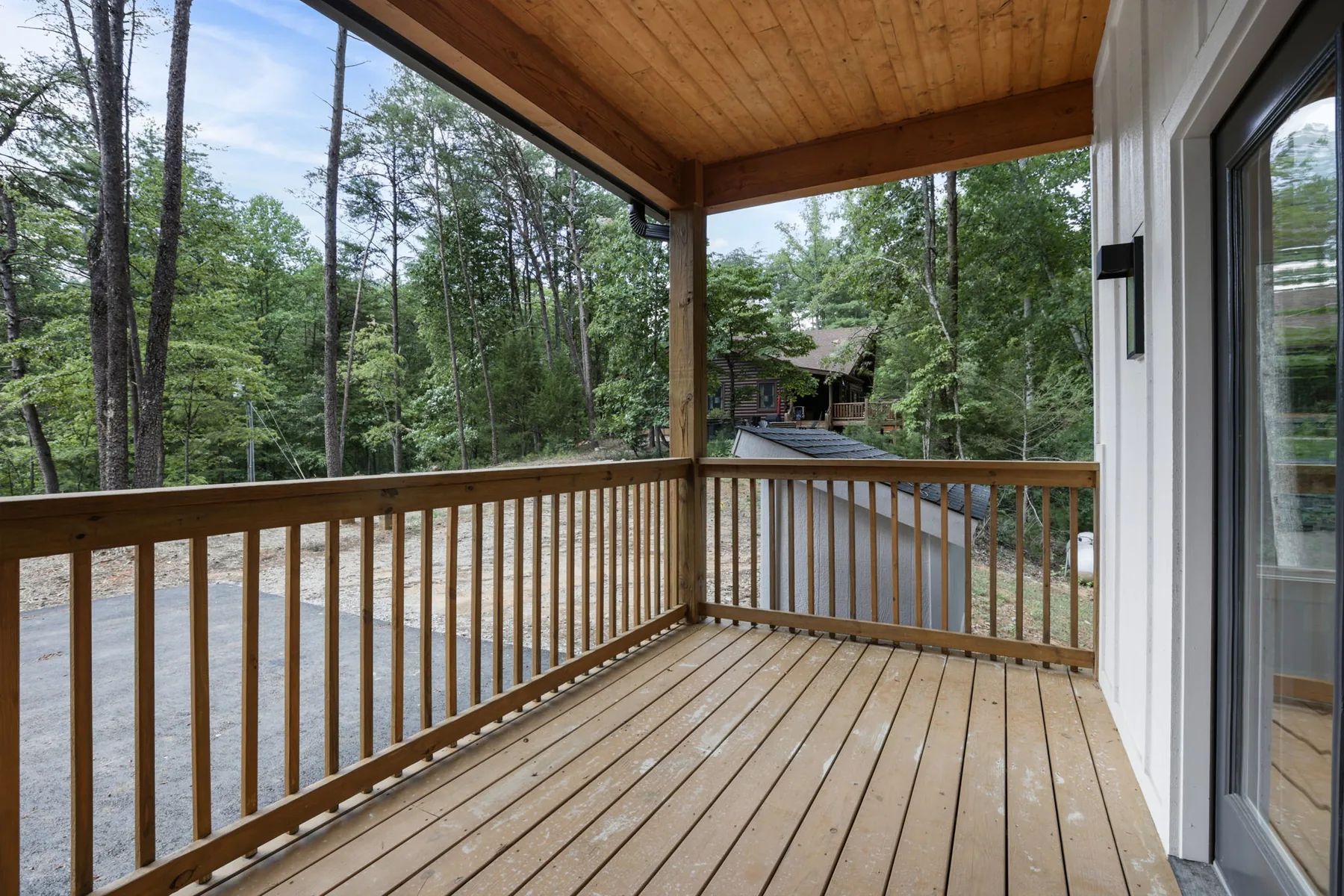 Wrap-around covered deck with a wood ceiling looking into the trees, Lake Lure NC