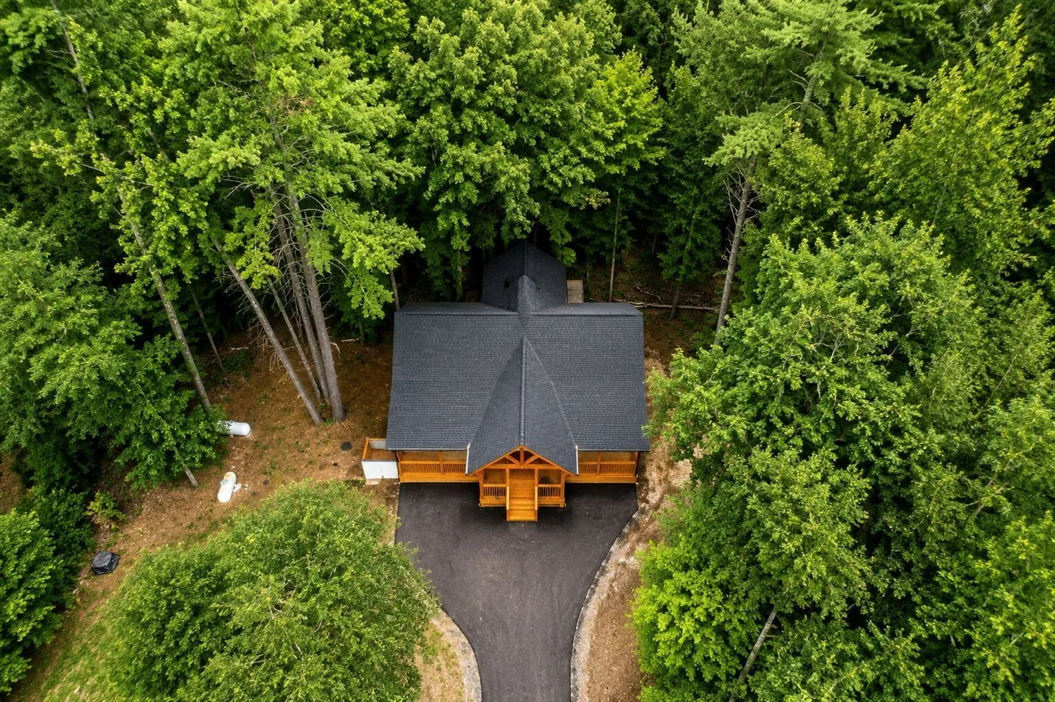 Aerial view of a finished custom home surrounded by forest, Lake Lure NC
