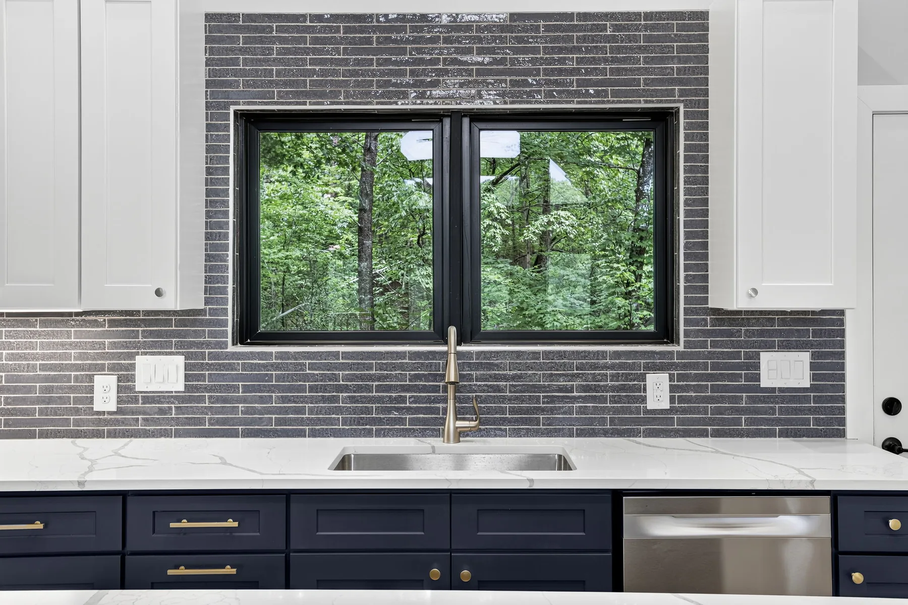 Kitchen sink run with quartz counters, brass tap and grey tile backsplash